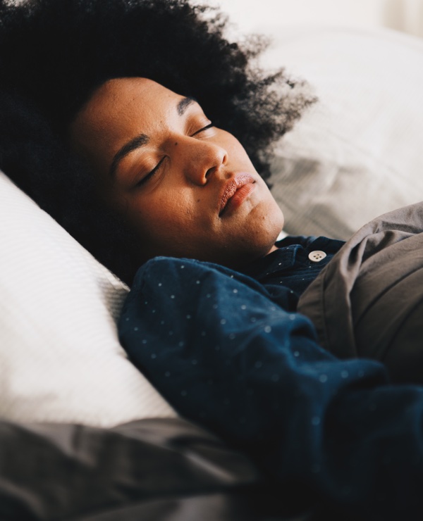 Woman sleeping
            soundly in her bed