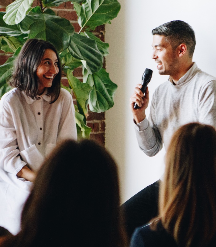 Speakers sitting on a panel speaking into microphone to answer an audience question