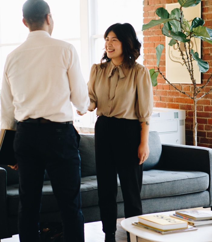 Hiring manager and interviewee shaking hands at the beginning of a job interview