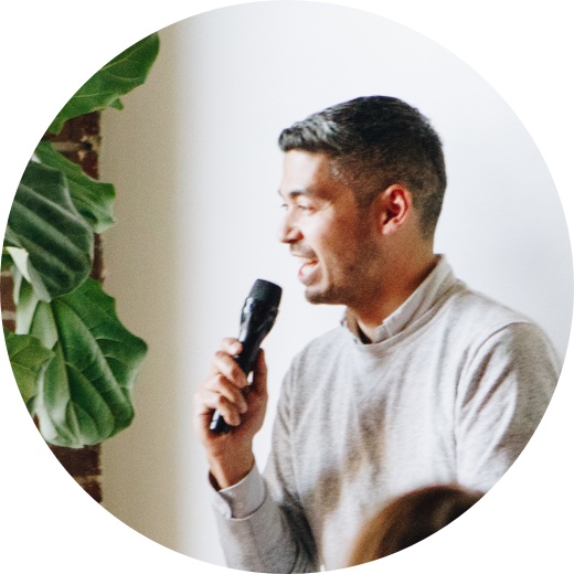 man speaking into microphone in front of audience during
                presentation